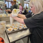 Volunteer preparing individual meals at Soul Hub's community kitchen in Newcastle, supporting community food relief initiatives.