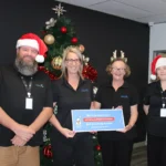 Four Blue Badge Insurance team members supporting Ronald McDonald House Charities' 12 Days of Christmas gift-matching campaign.