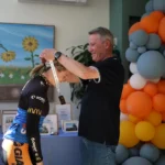 Cyclist receiving a medal at a charity fundraising event supporting sick children.